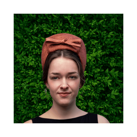 Model wearing a bronze turban by Jo Ramsay Millinery