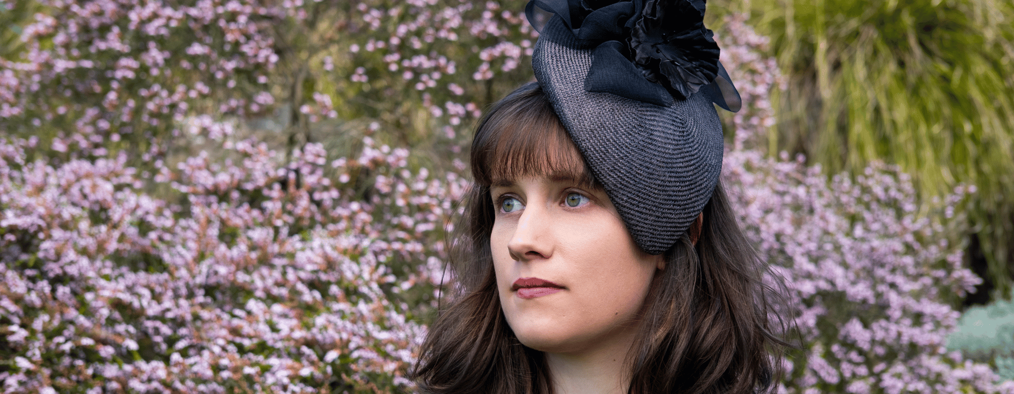 Model wearing a dark grey face hugger by Jo Ramsay Millinery